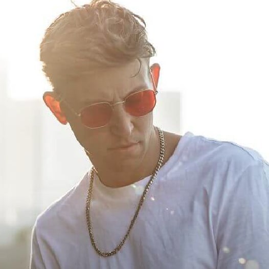 Matt in red sunglasses and a gold chain in golden light